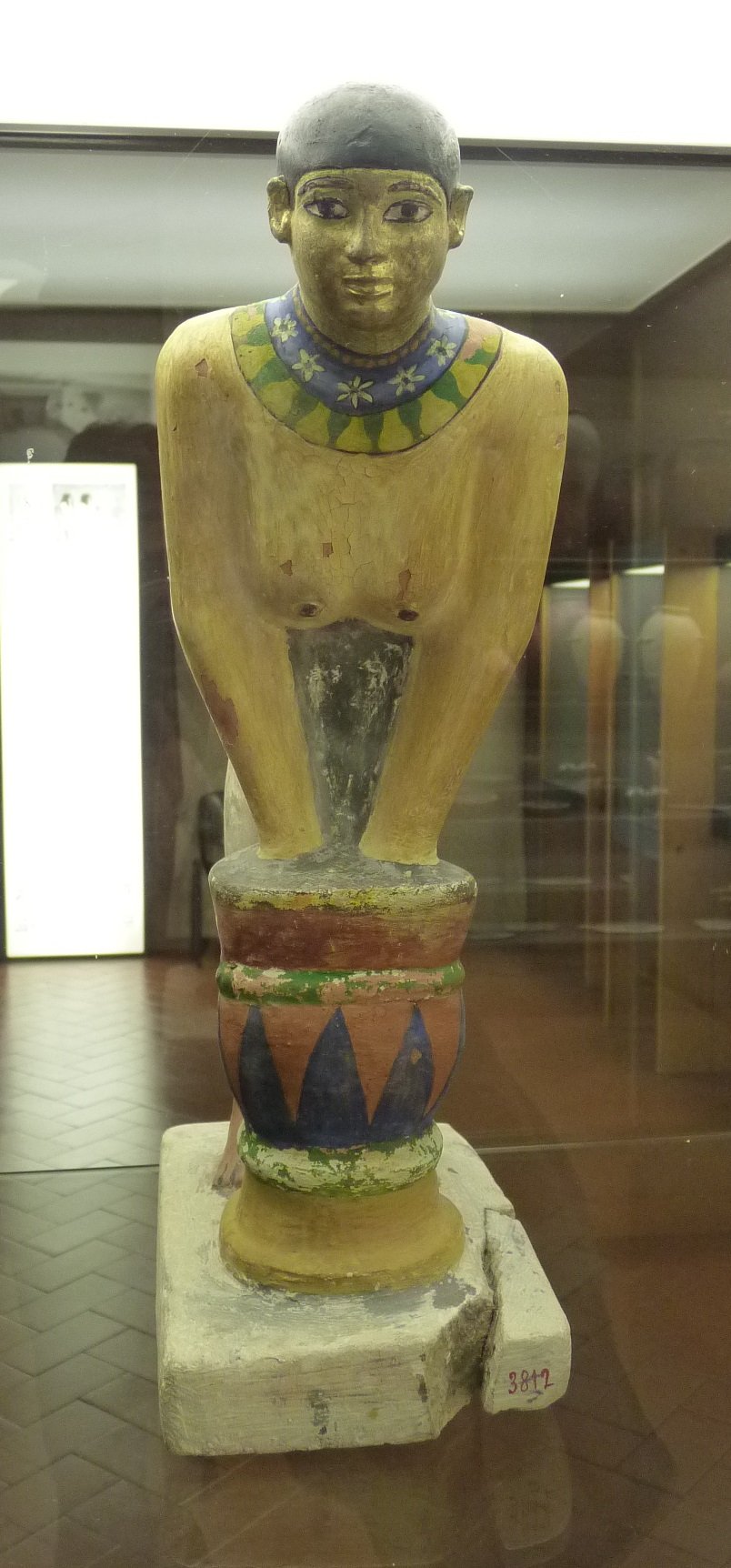 A painted-limestone Old Kingdom tomb model of a woman making beer by straining fermented barley bread — beer was daily food, wages, and offering in ancient Egypt.